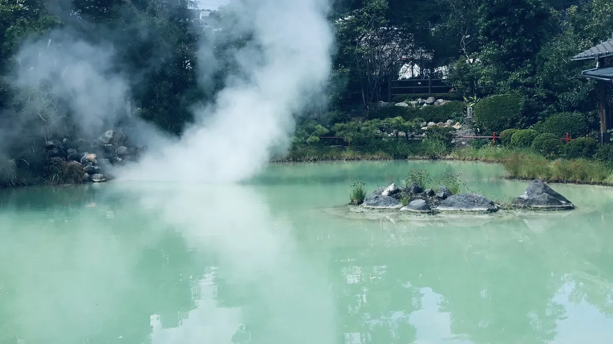青白い色の湯をたたえる白池地獄
